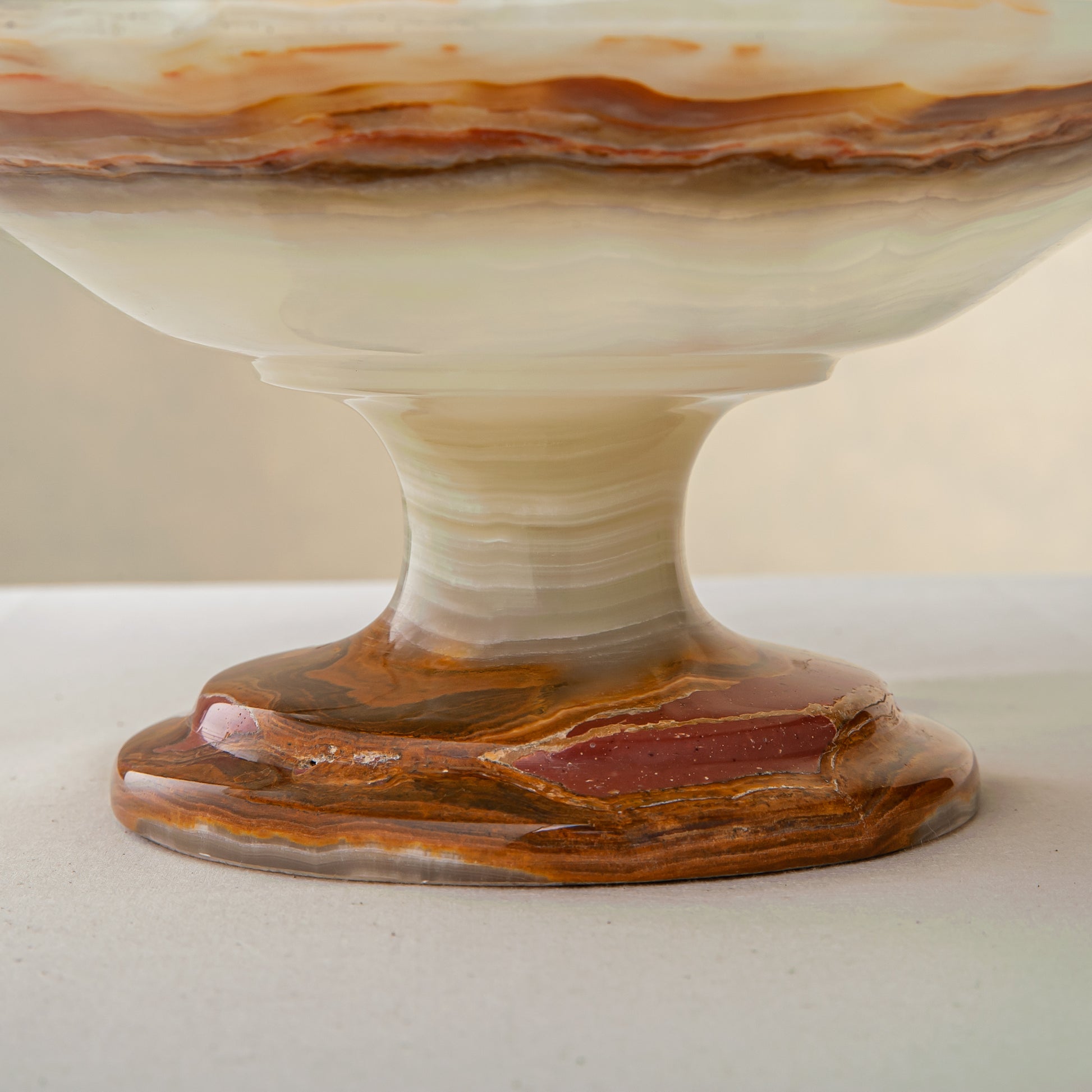 handcrafted onyx bowl with pedestal base and translucent layered amber veining for luxury decor
