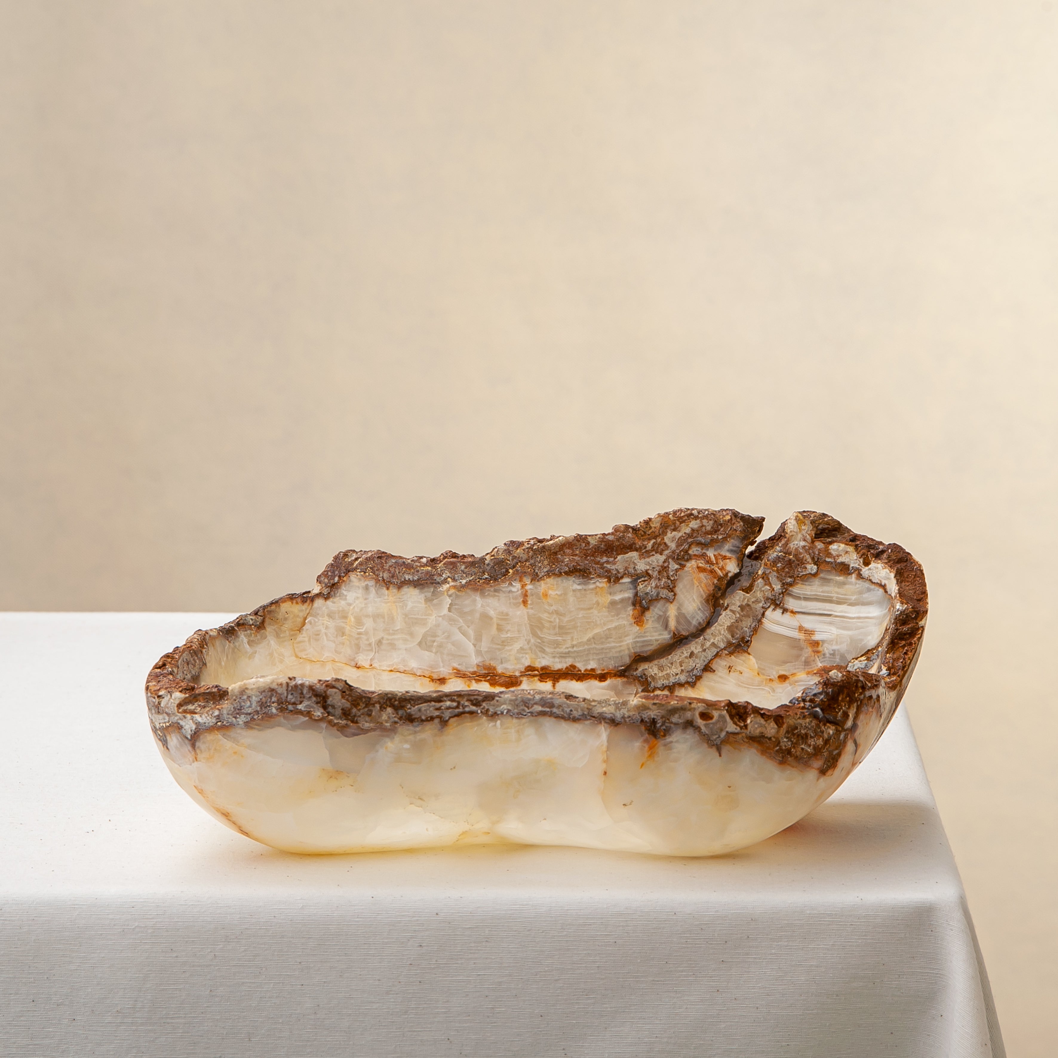 Handcrafted onyx bowl with raw edge and ivory amber tones for luxury table decor
