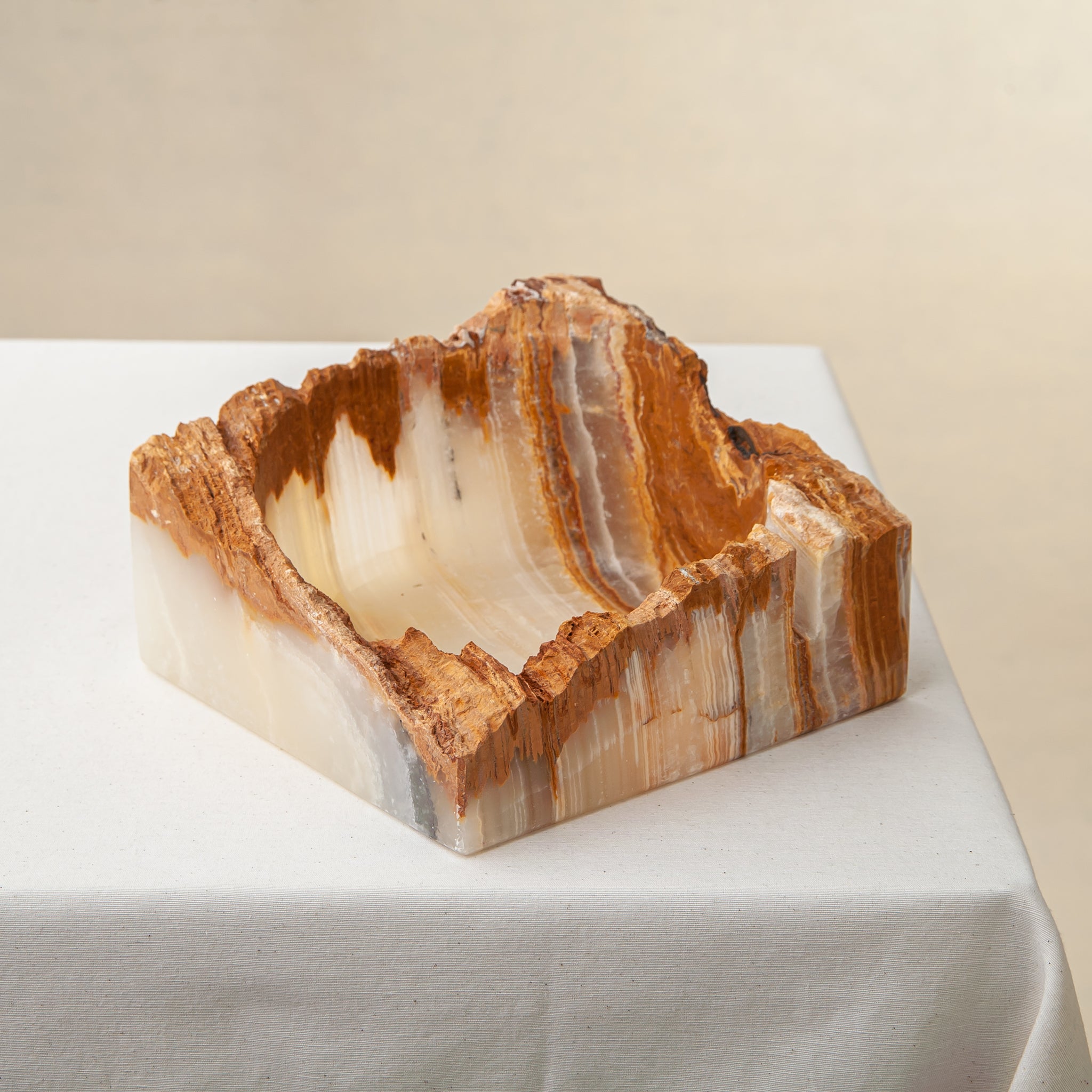 handcrafted rough onyx bowl with raw edges in white and amber tones for statement decor
