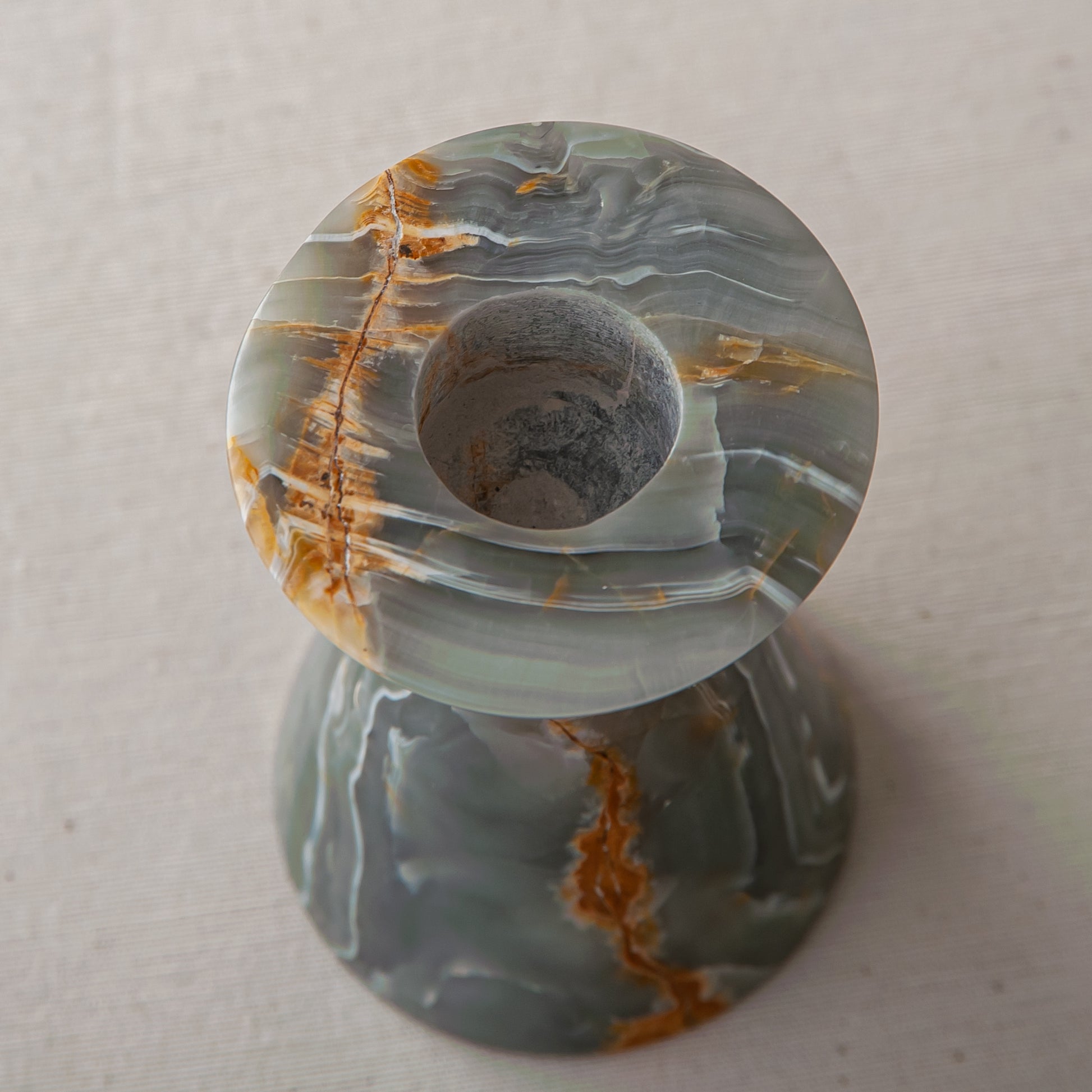 handcrafted onyx candle holder with green grey tones and amber veining for ambient decor