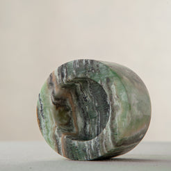 Handcrafted green onyx candle holder with natural banding and cylindrical sculptural form

