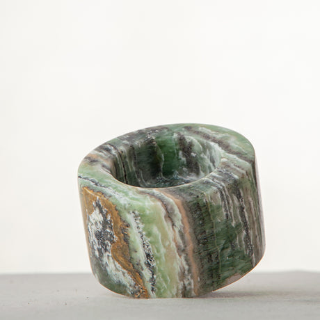 Handcrafted green onyx candle holder with natural banding and cylindrical sculptural form
