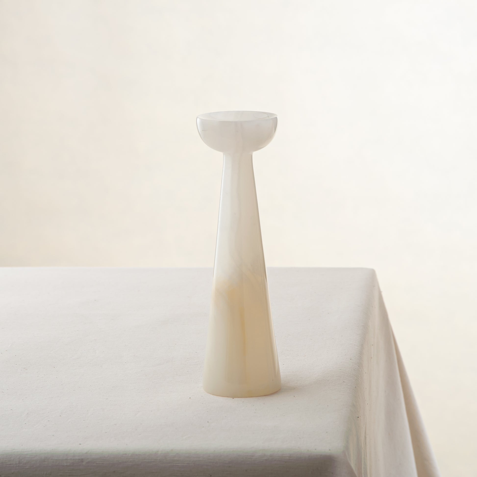 Unique onyx candle holder with ivory translucency and elongated sculptural form
