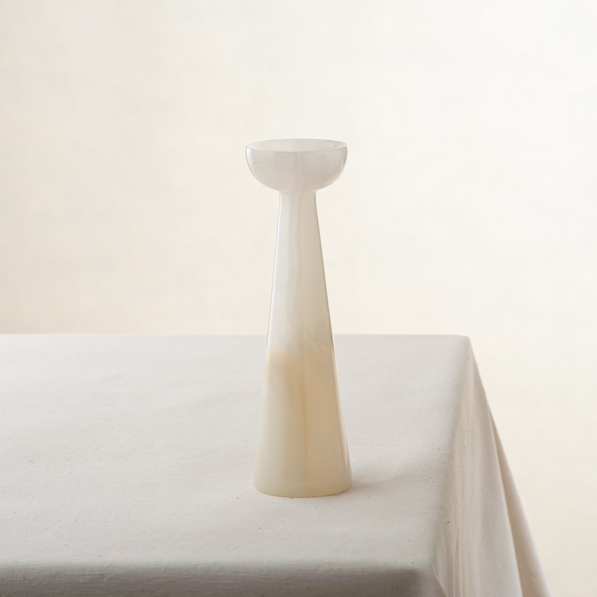 Unique onyx candle holder with ivory translucency and elongated sculptural form
