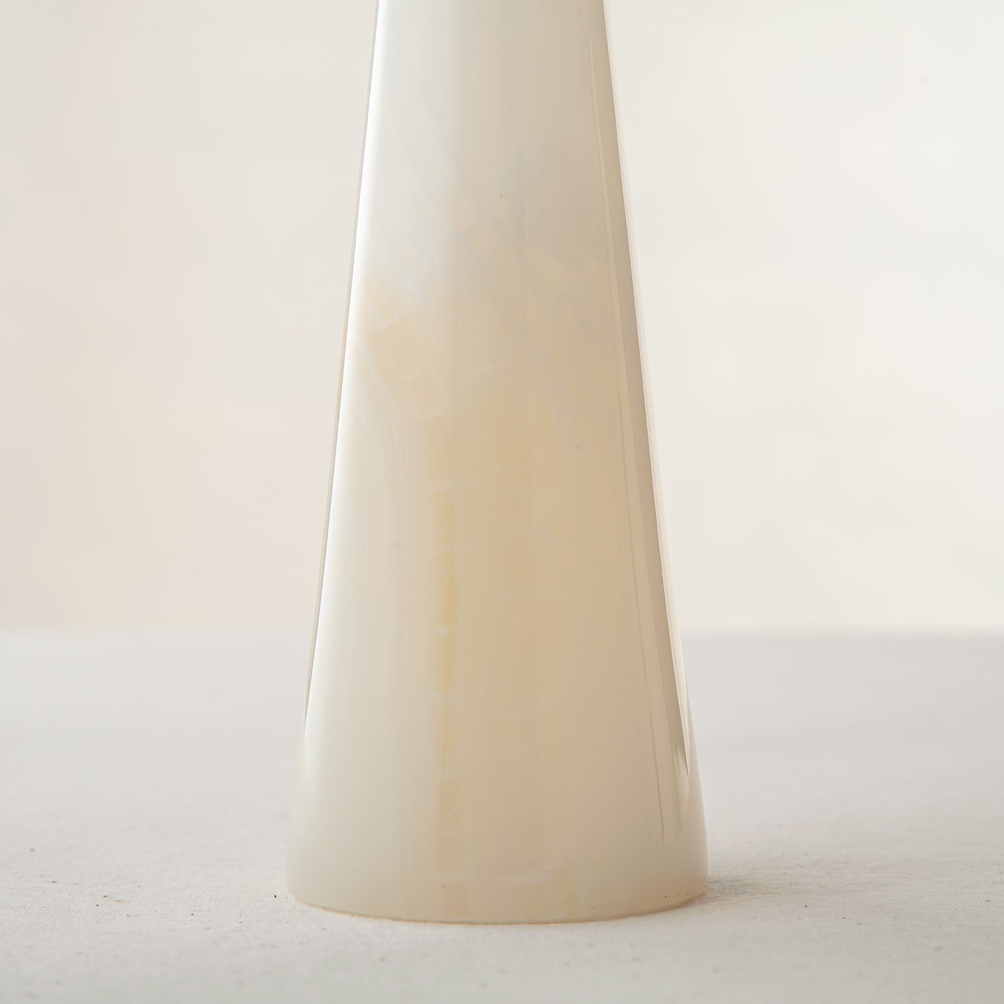 Unique onyx candle holder with ivory translucency and elongated sculptural form
