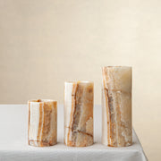 Unique onyx candle holder set with amber veining and cylindrical sculptural forms
