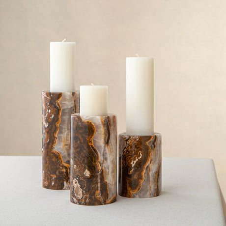 Handcrafted onyx candle holders featuring layered texture and warm earthy colors for elegant table decor
