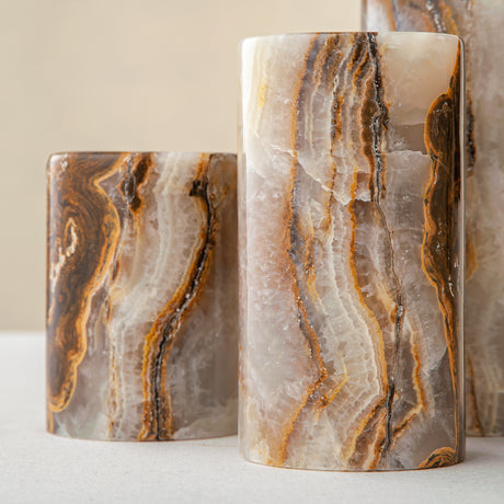 Handcrafted onyx candle holders featuring layered texture and warm earthy colors for elegant table decor

