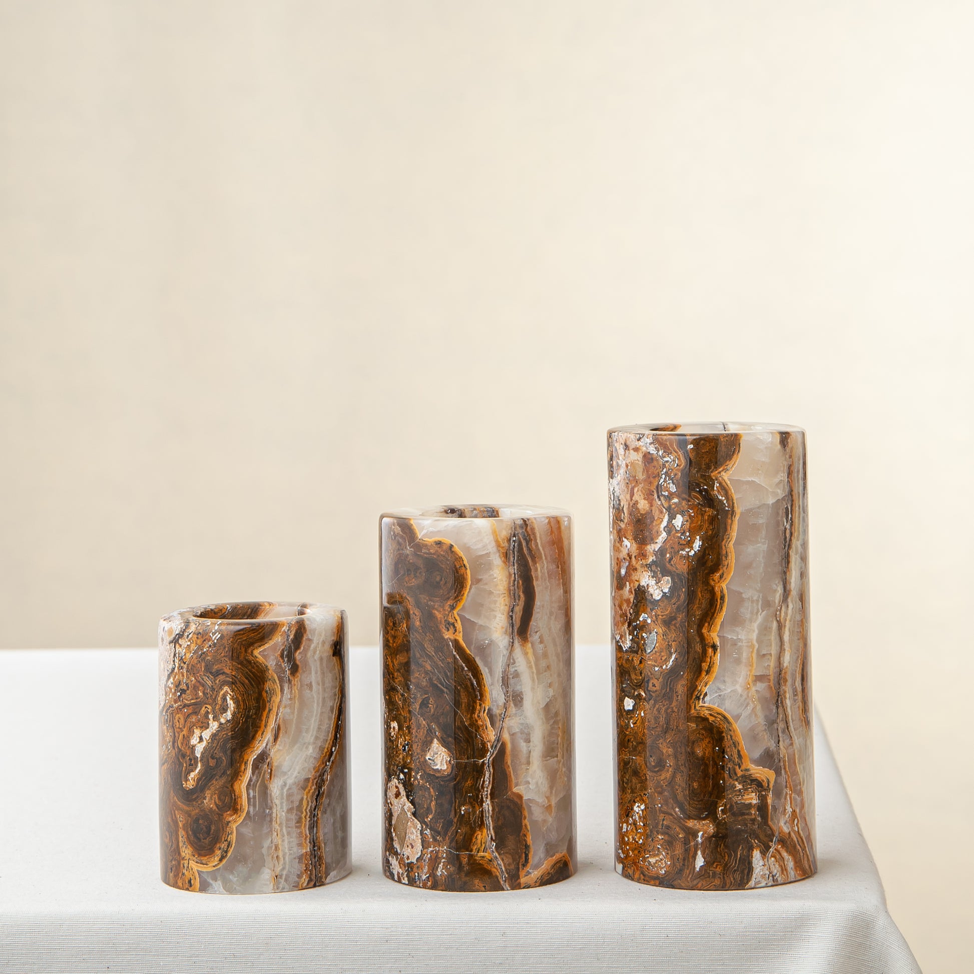 Handcrafted onyx candle holders featuring layered texture and warm earthy colors for elegant table decor
