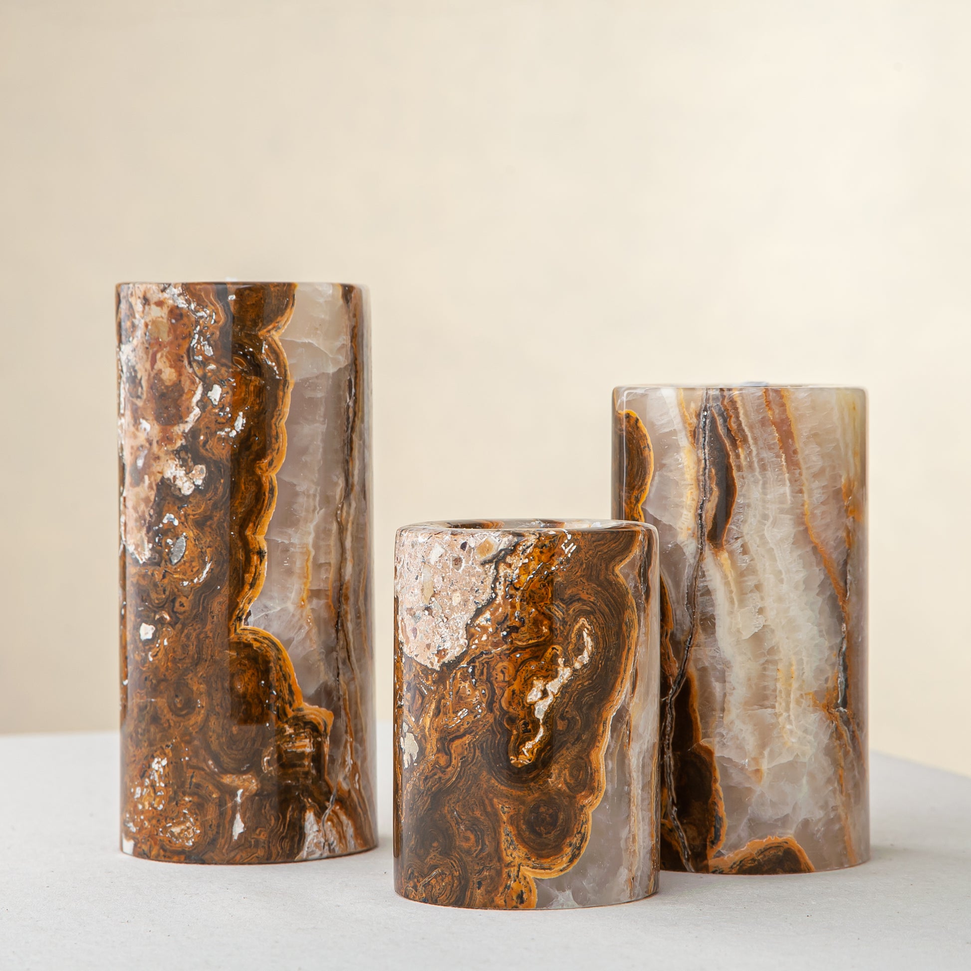Handcrafted onyx candle holders featuring layered texture and warm earthy colors for elegant table decor
