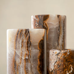 Handcrafted onyx candle holders featuring layered texture and warm earthy colors for elegant table decor
