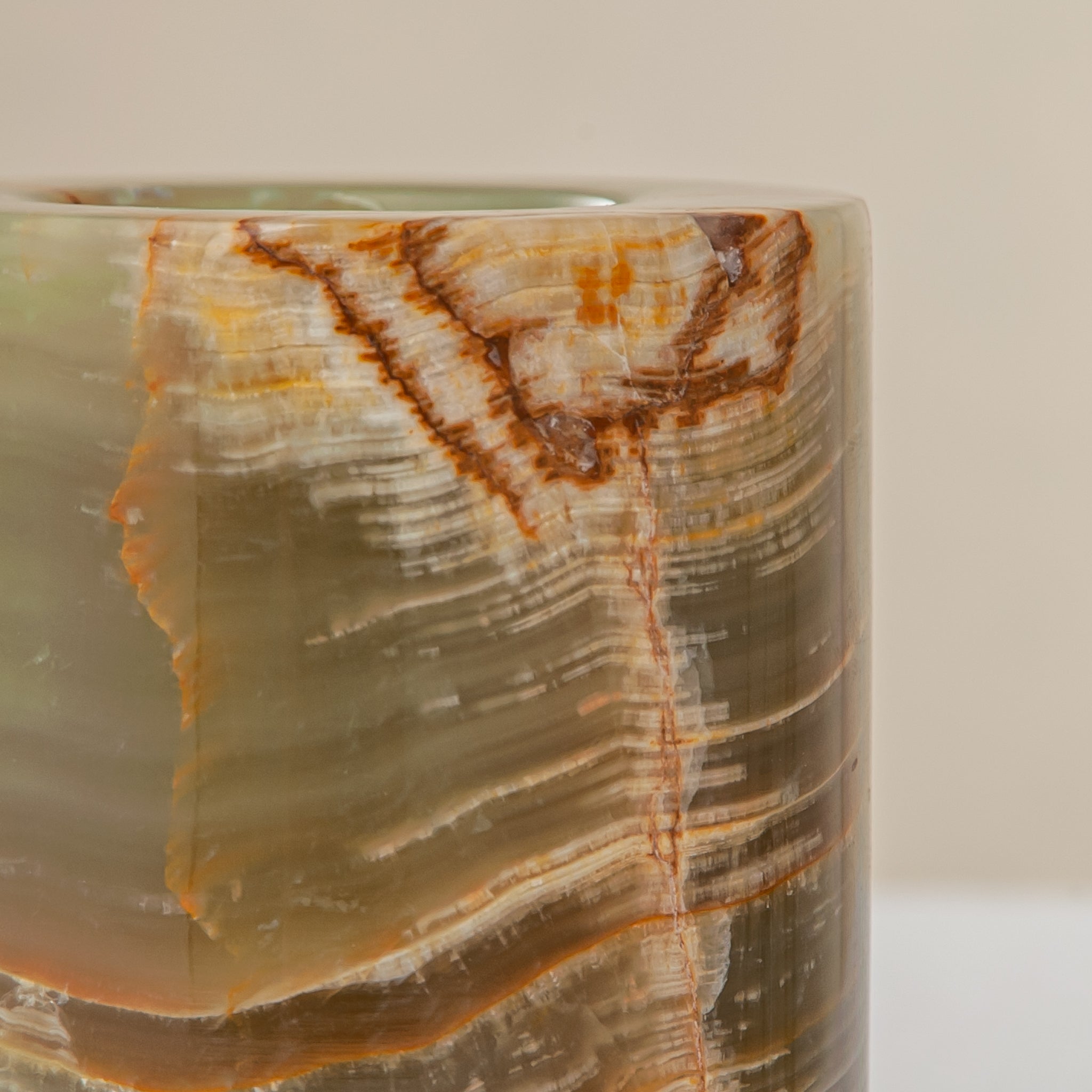 handcrafted onyx candle holder with translucent layered bands and warm amber veining for modern decor
