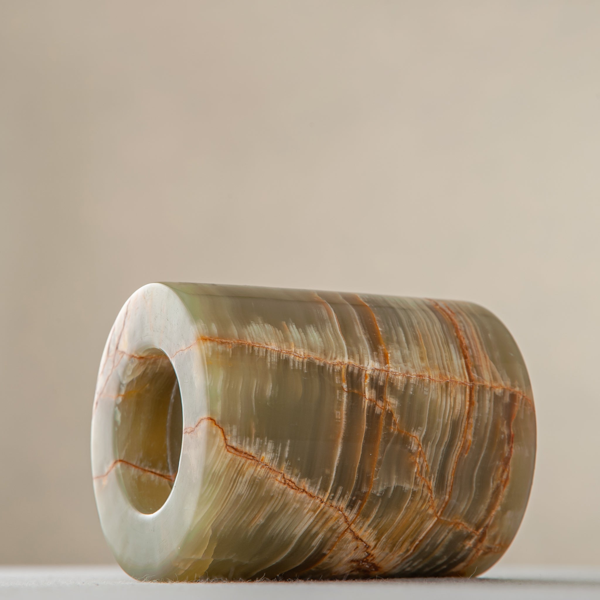 handcrafted onyx candle holder with translucent layered bands and warm amber veining for modern decor
