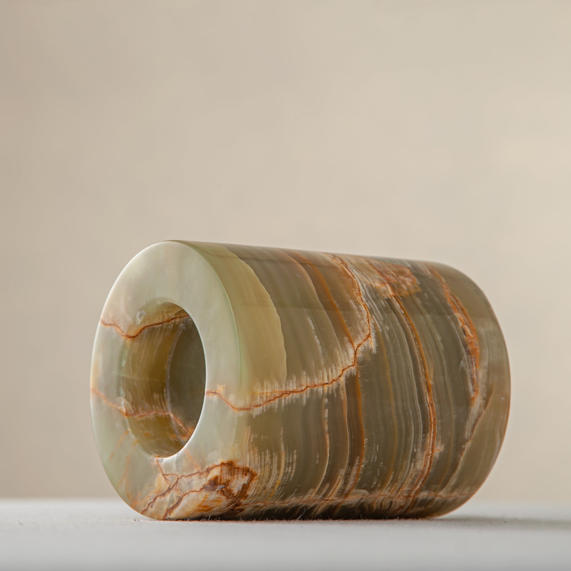 handcrafted onyx candle holder with translucent layered bands and warm amber veining for modern decor
