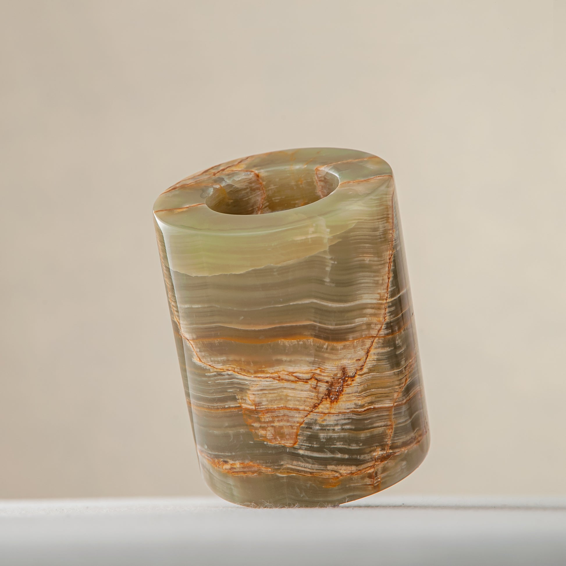 handcrafted onyx candle holder with translucent layered bands and warm amber veining for modern decor
