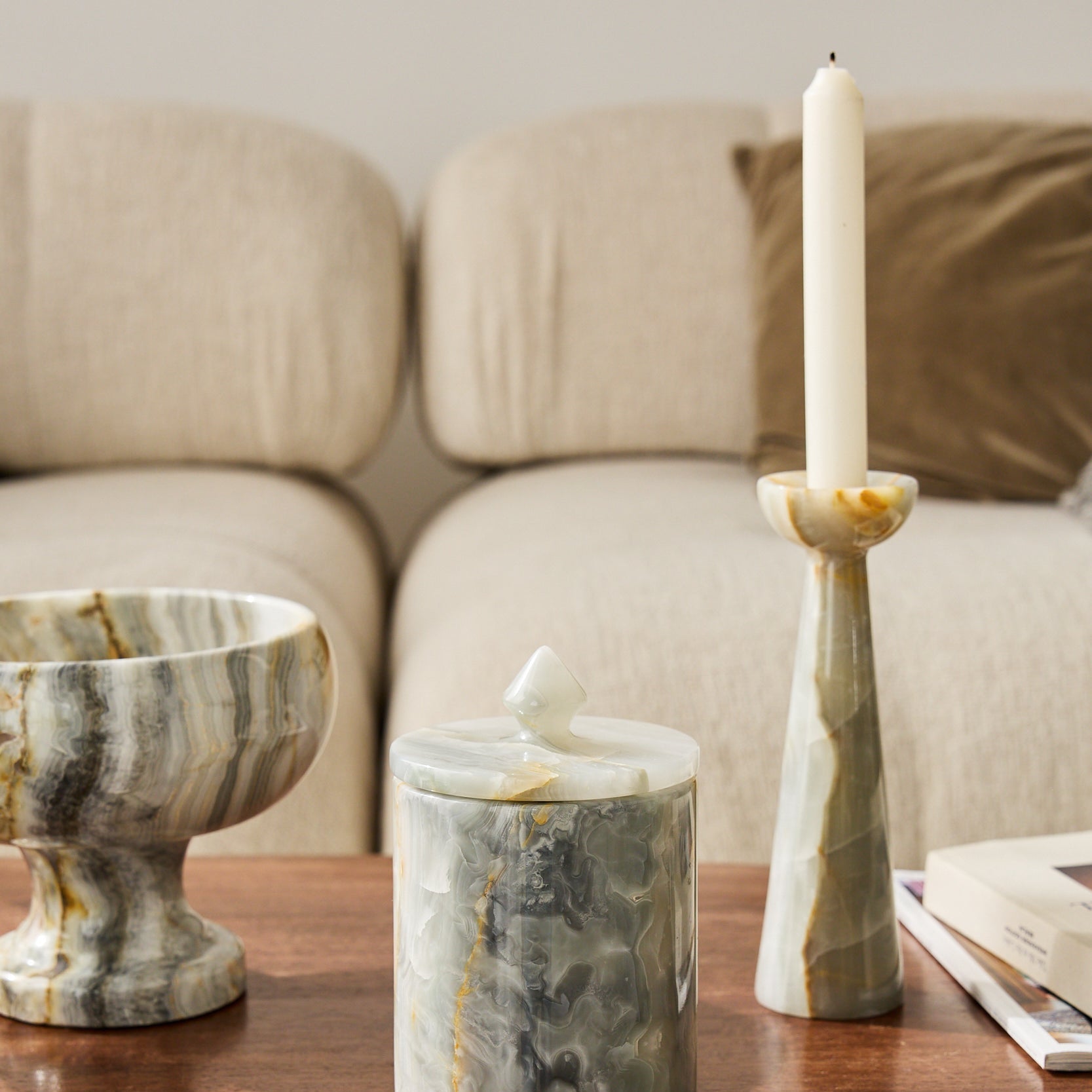 Handcrafted onyx candle holder with tall sculptural form and amber veining for modern decor
