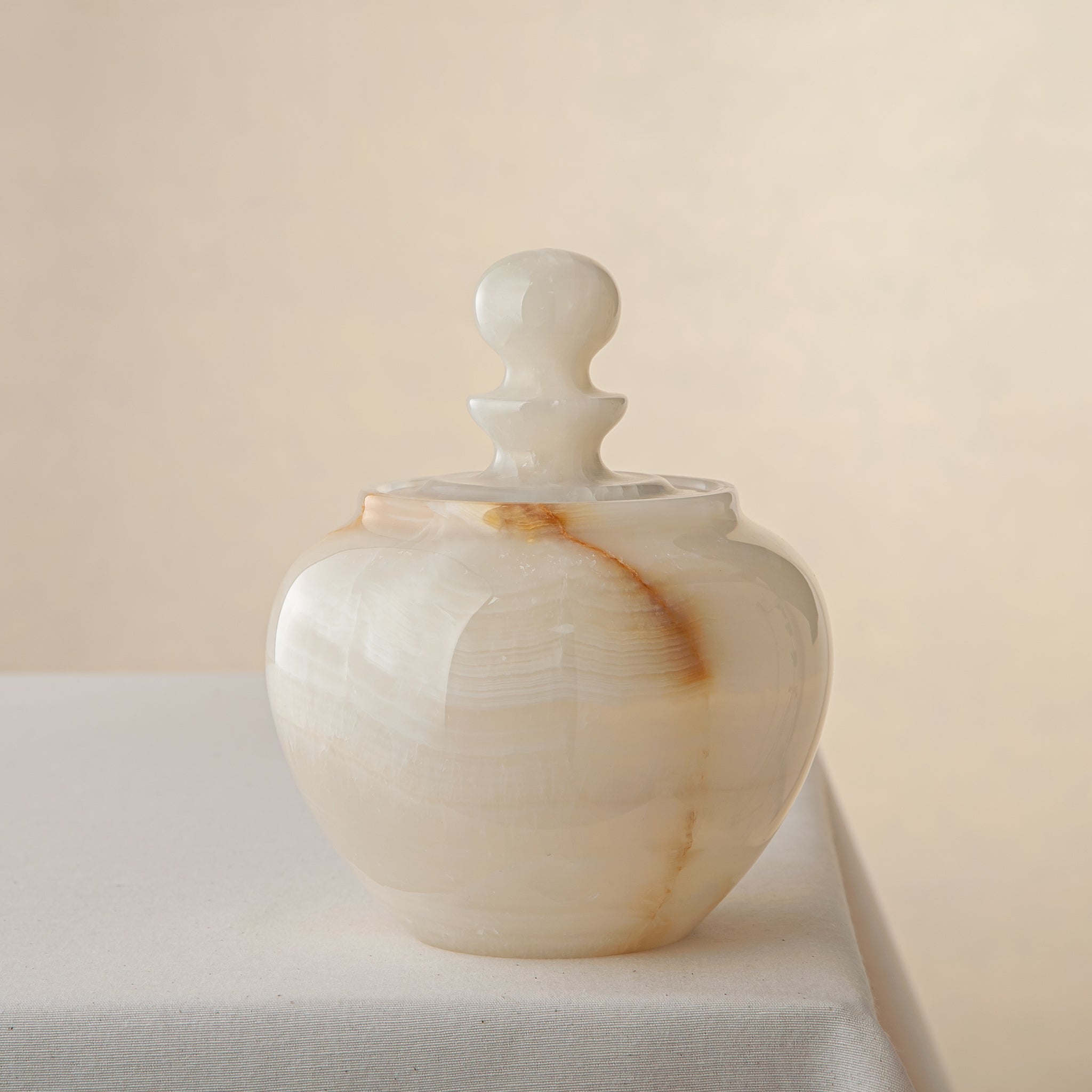 handcrafted onyx jar with translucent ivory stone and warm amber veining
