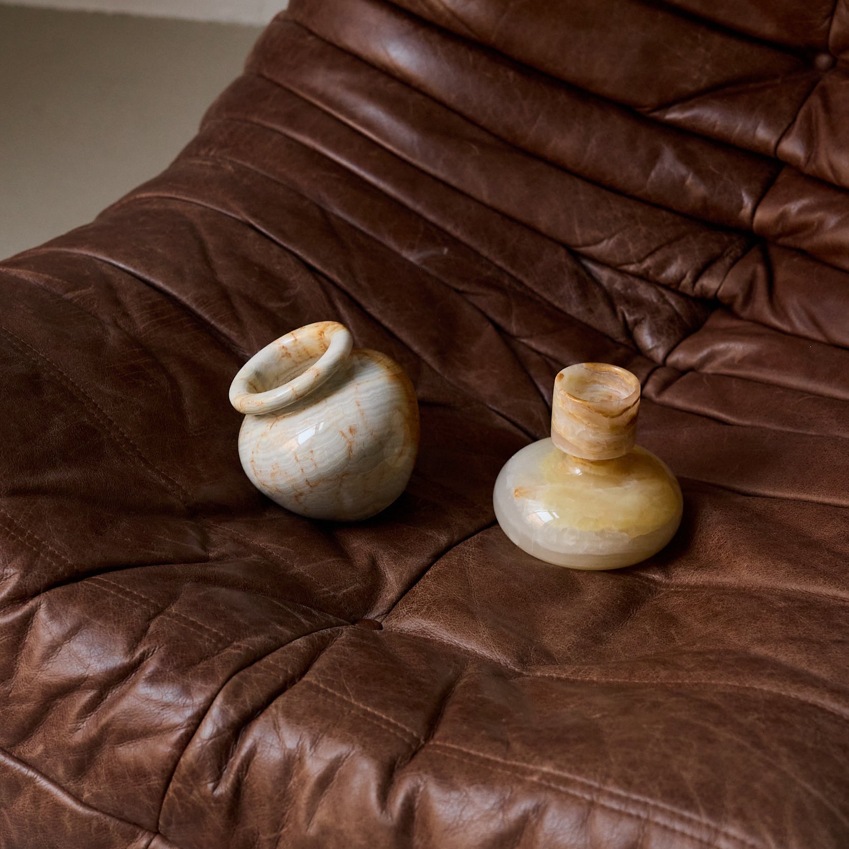 Handcrafted onyx vase with layered ivory and amber veining sculptural decor
