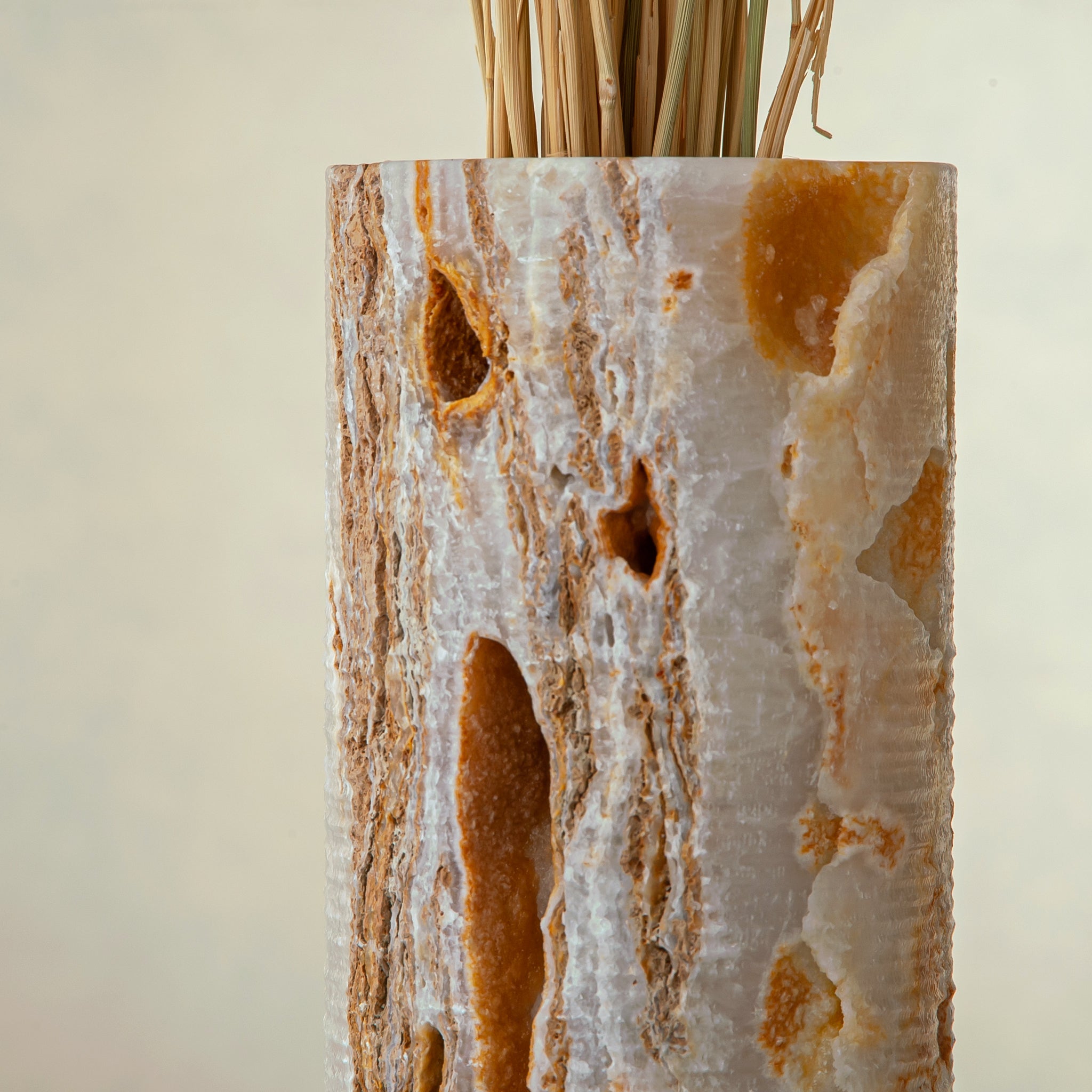 handcrafted onyx vase with warm amber veining and natural cavities for luxury interior decor
