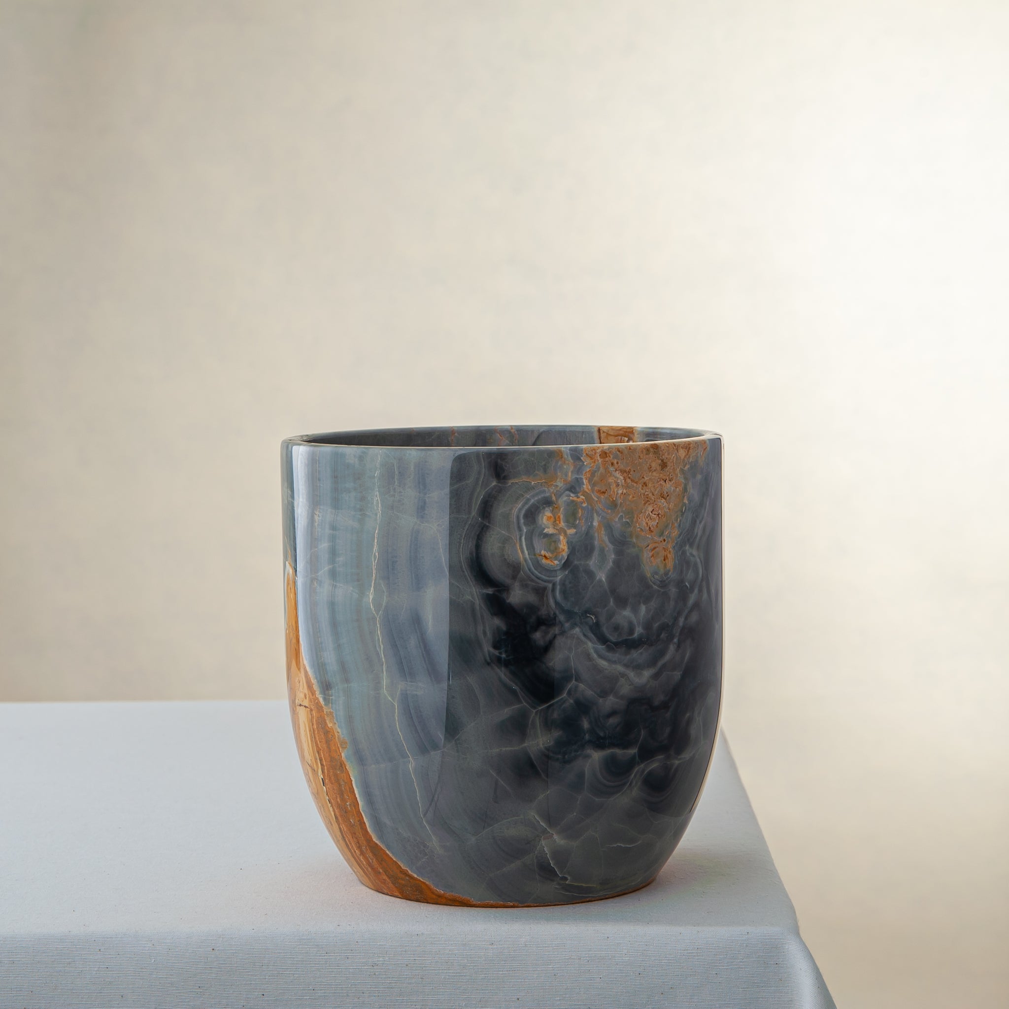 handcrafted onyx vase in blue grey stone with amber veining as a luxury centerpiece
