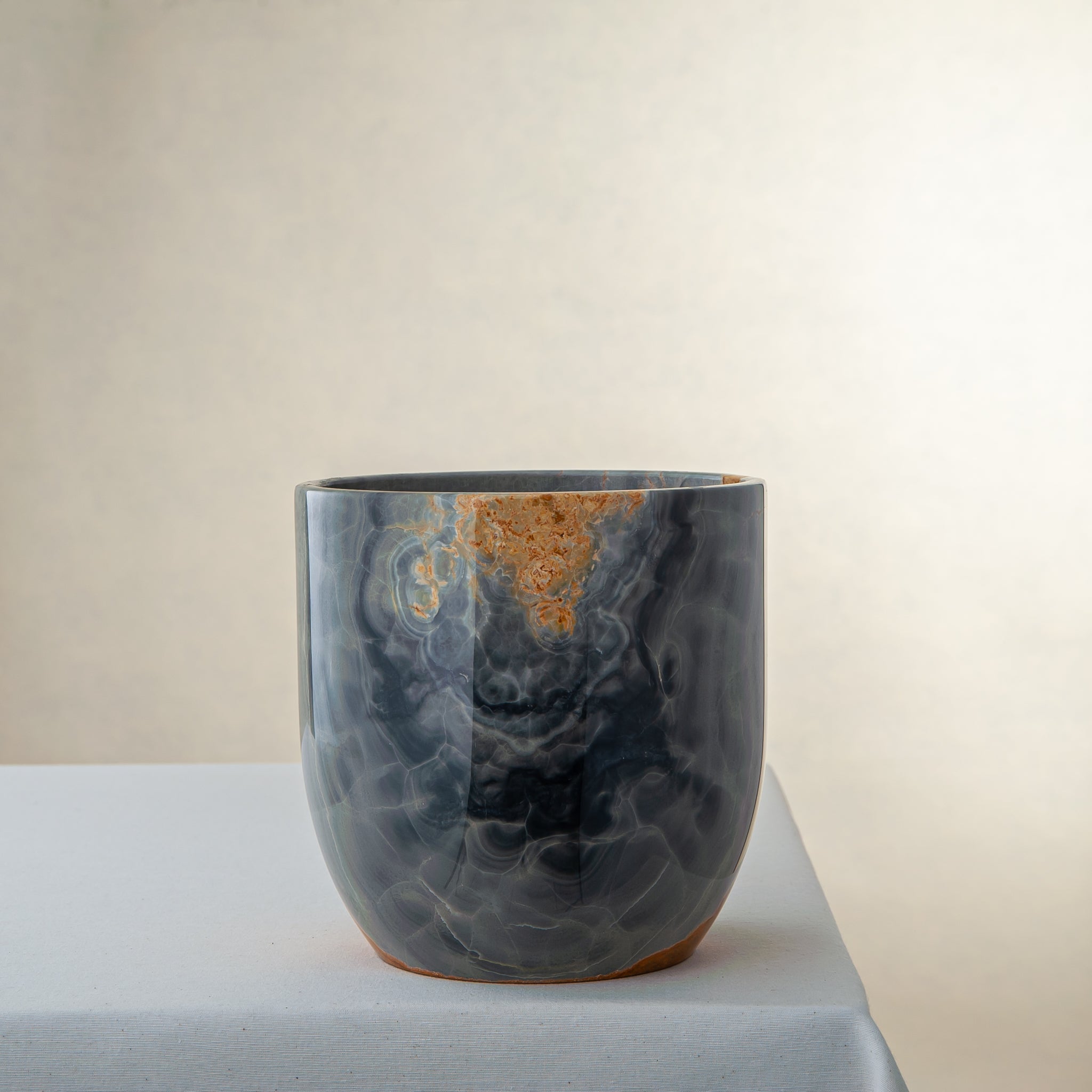 handcrafted onyx vase in blue grey stone with amber veining as a luxury centerpiece
