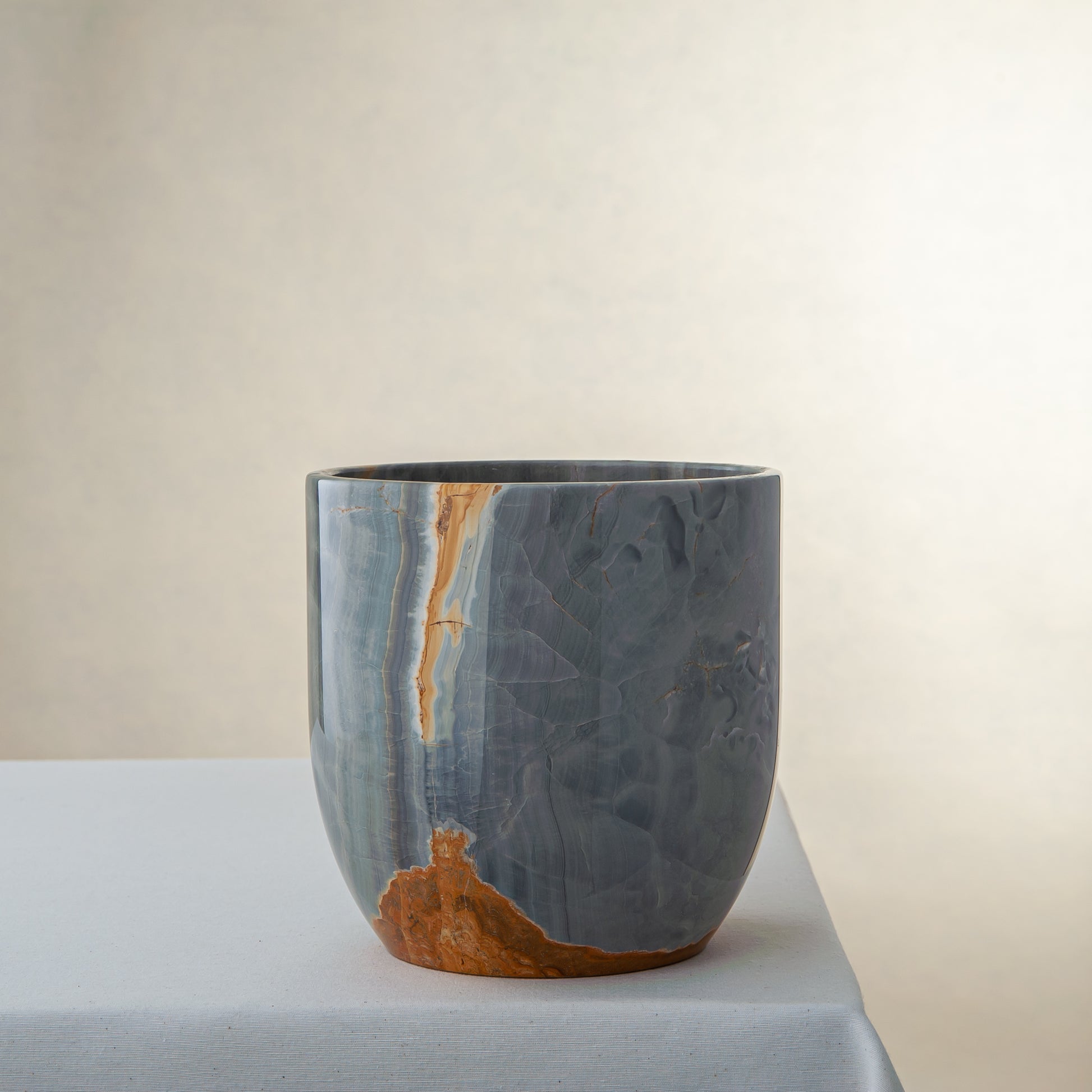 handcrafted onyx vase in blue grey stone with amber veining as a luxury centerpiece
