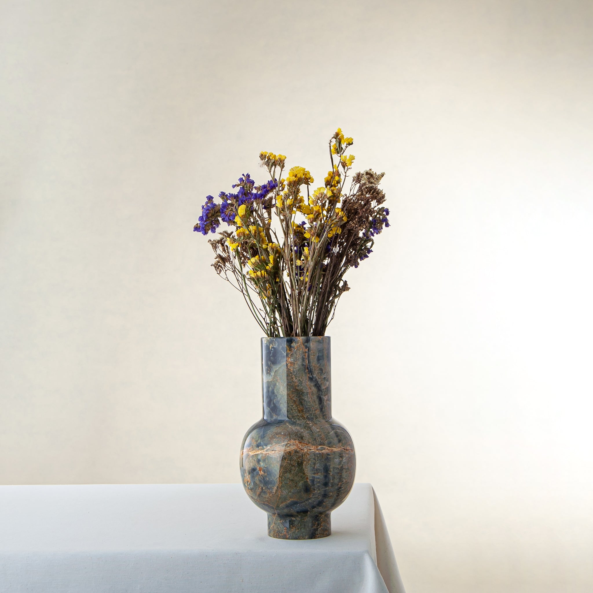 Handcrafted onyx vase with deep green tones and rust veining for luxury interior decor

