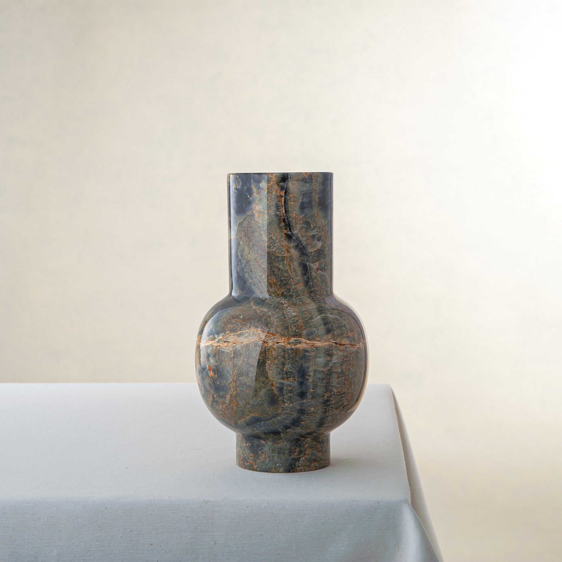 Handcrafted onyx vase with deep green tones and rust veining for luxury interior decor

