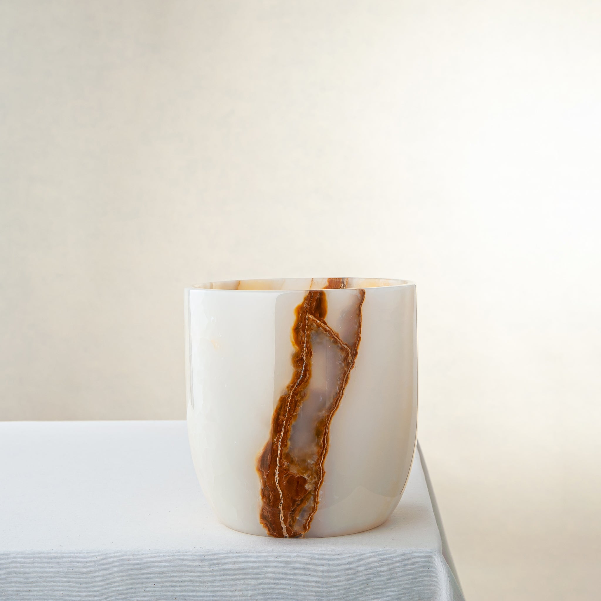 handcrafted onyx vase with ivory surface and bold amber vertical veining
