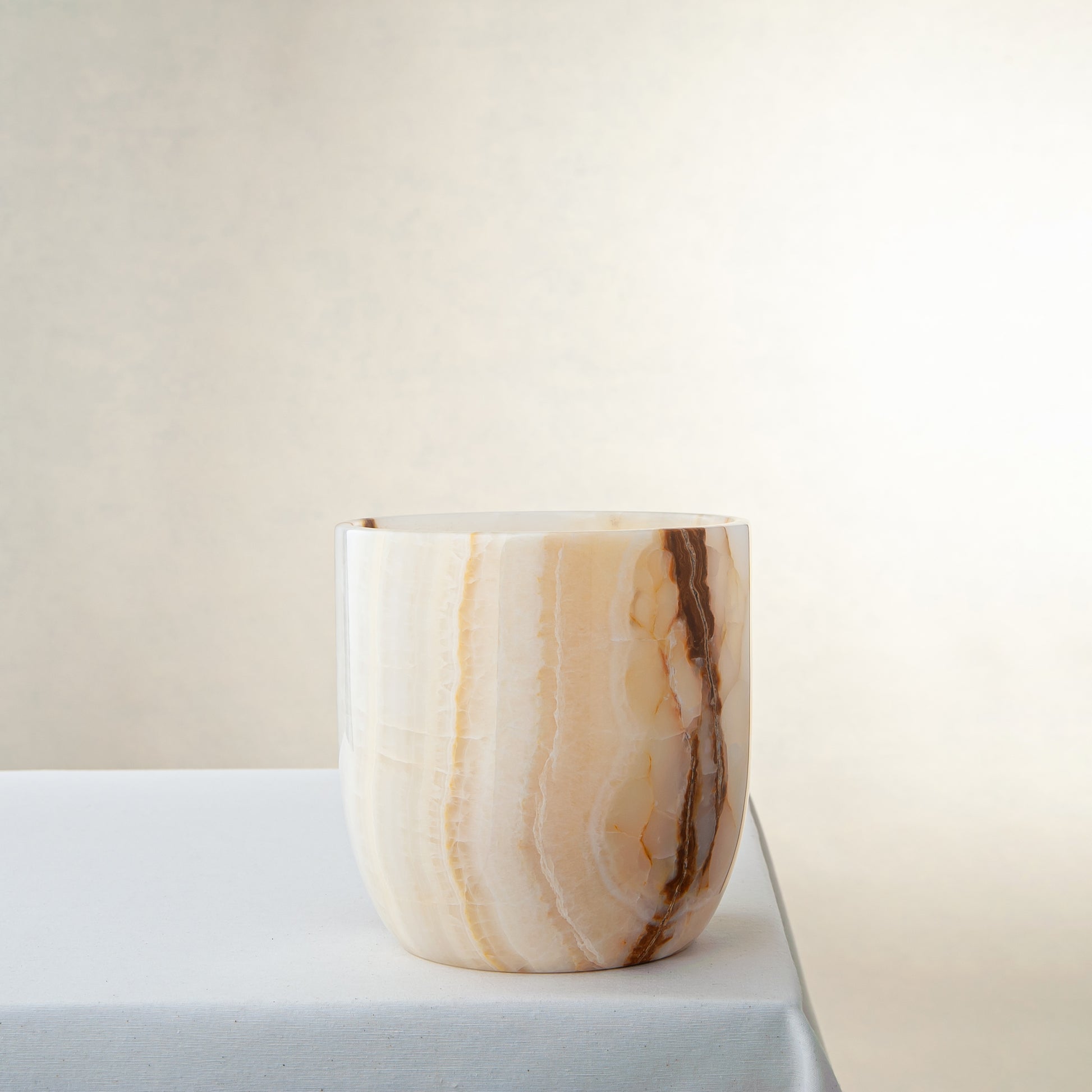 handcrafted onyx vase with ivory surface and bold amber vertical veining
