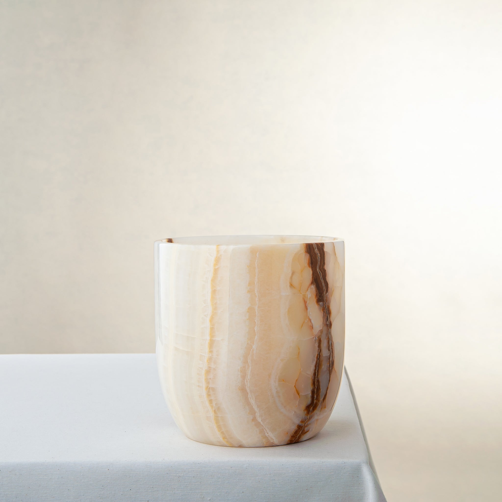 handcrafted onyx vase with ivory surface and bold amber vertical veining
