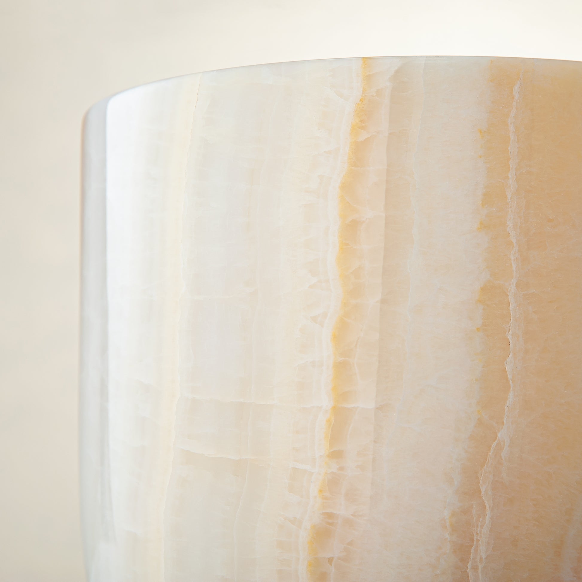 handcrafted onyx vase with ivory surface and bold amber vertical veining
