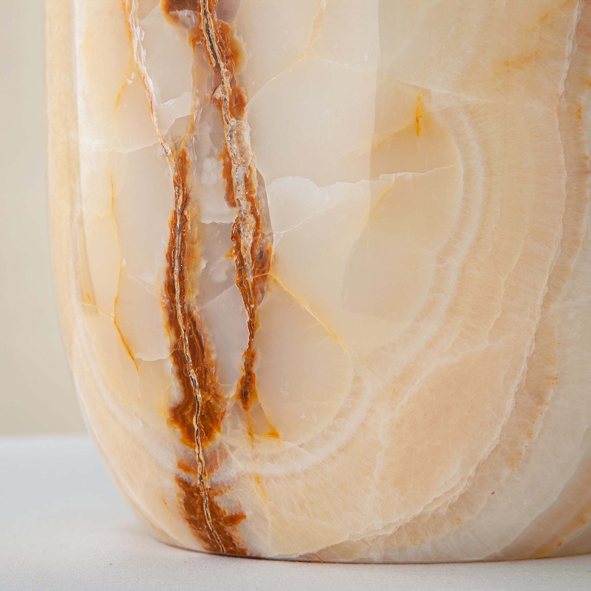 handcrafted onyx vase with ivory surface and bold amber vertical veining
