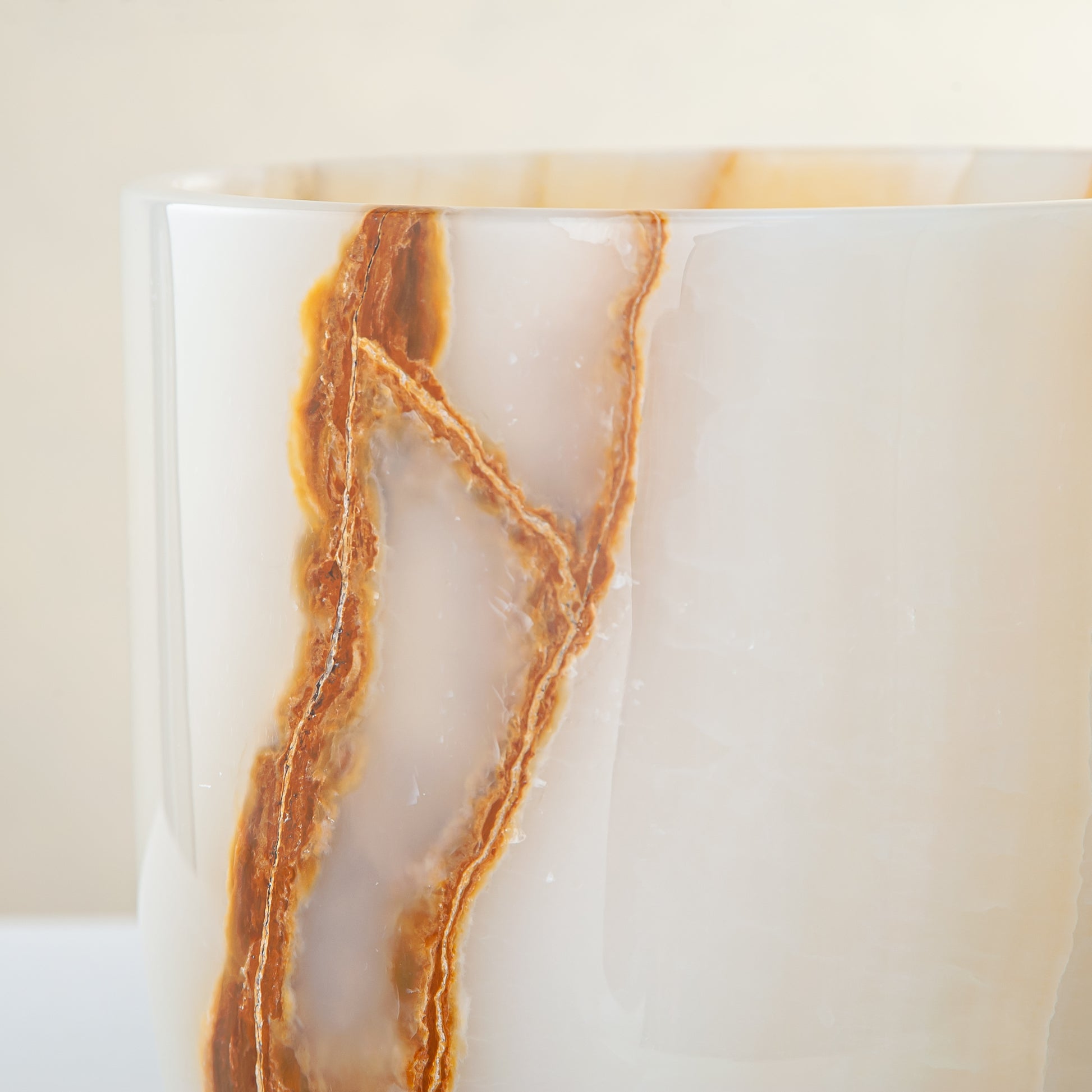 handcrafted onyx vase with ivory surface and bold amber vertical veining
