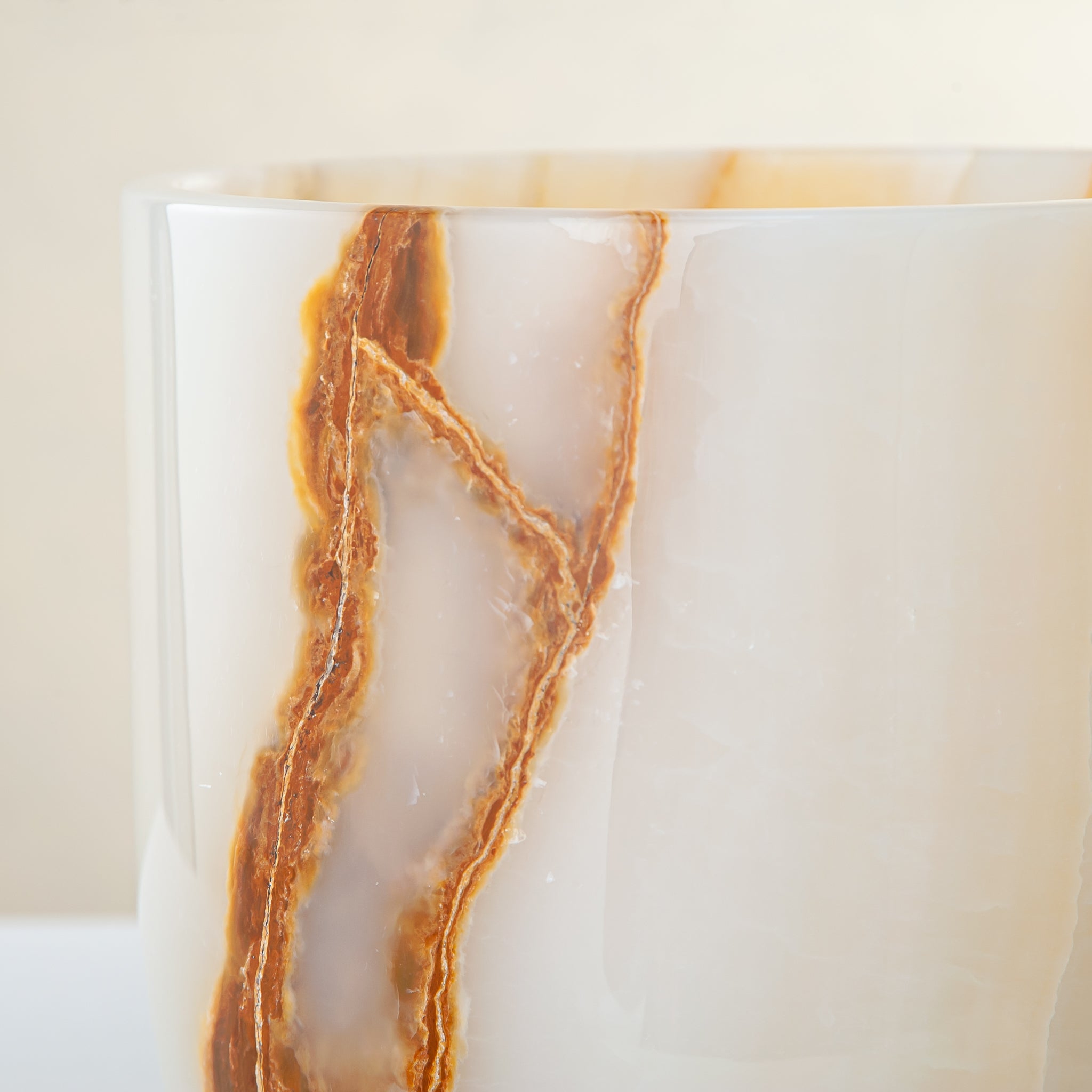 handcrafted onyx vase with ivory surface and bold amber vertical veining

