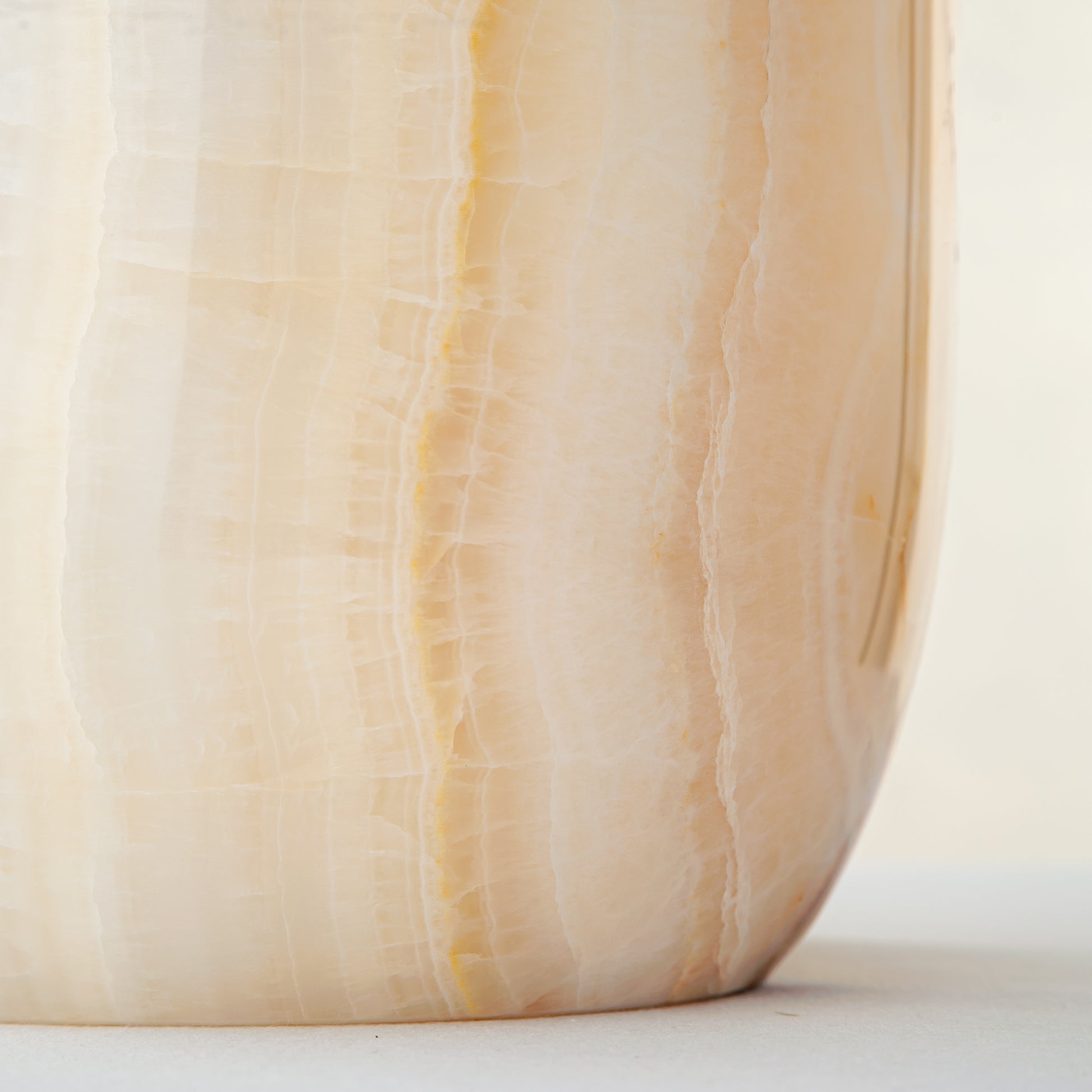 handcrafted onyx vase with ivory surface and bold amber vertical veining
