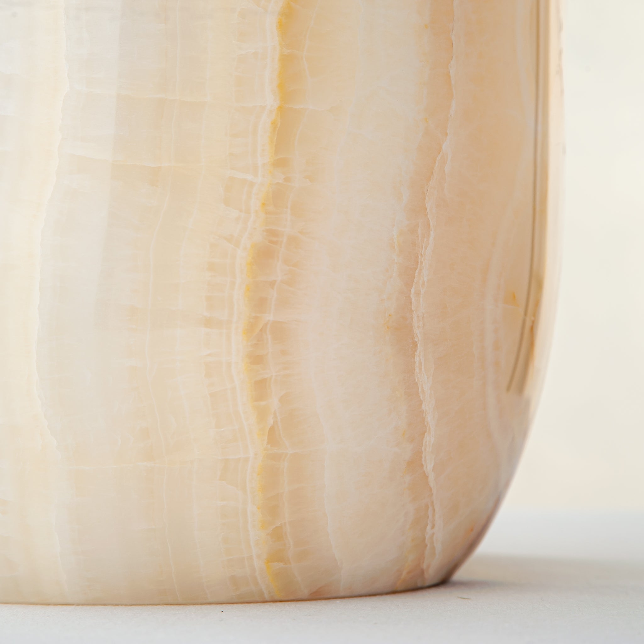 handcrafted onyx vase with ivory surface and bold amber vertical veining
