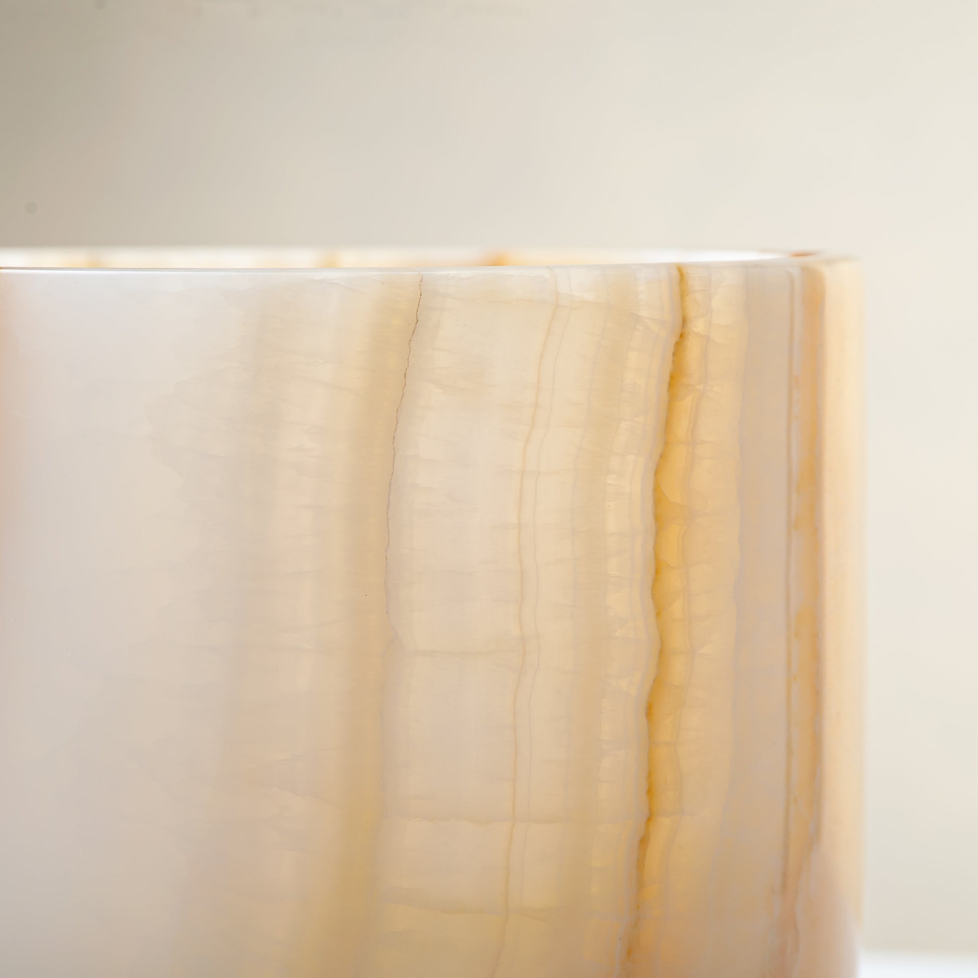 handcrafted onyx vase with ivory surface and bold amber vertical veining
