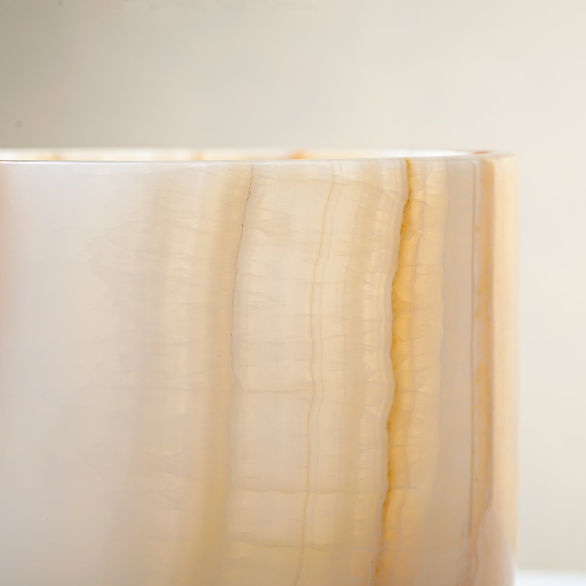 handcrafted onyx vase with ivory surface and bold amber vertical veining
