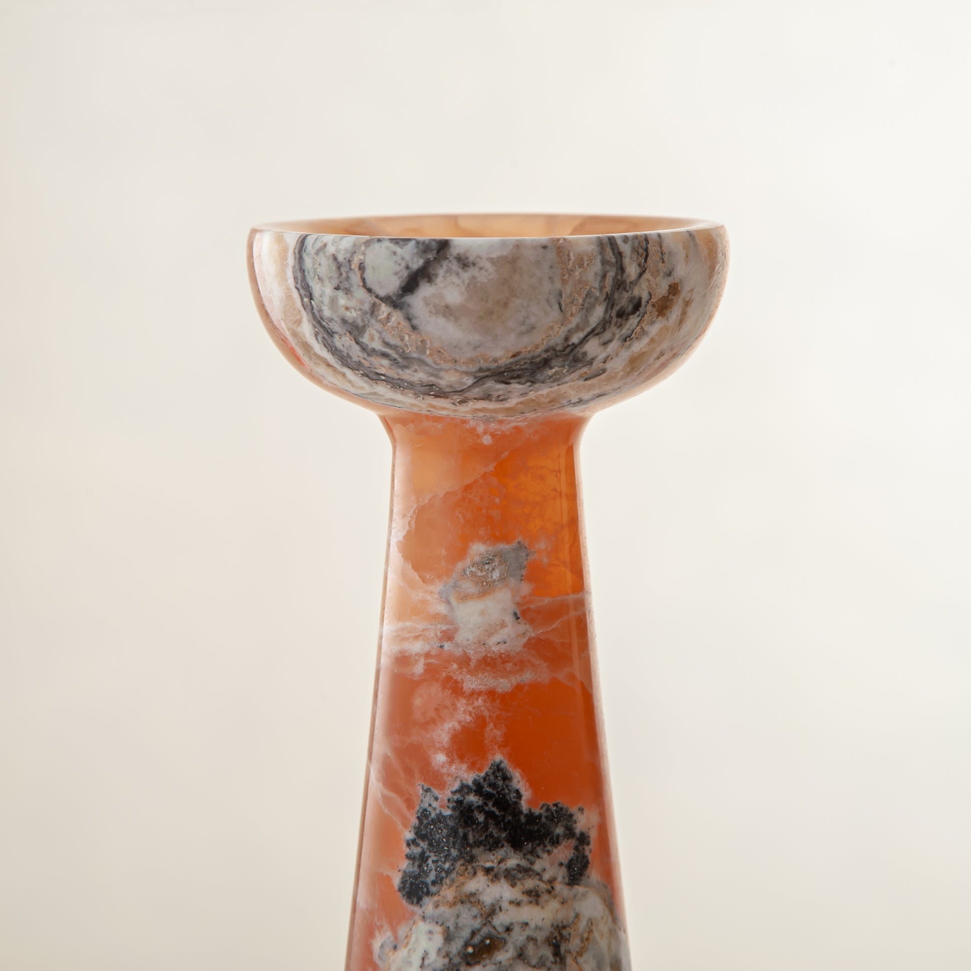 handcrafted orange onyx candle holder with tall sculptural form and translucent veining for modern decor
