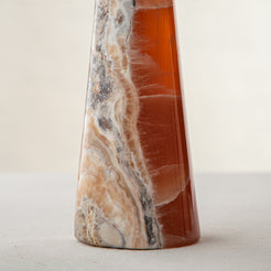 handcrafted orange onyx candle holder with tall sculptural form and translucent veining for modern decor
