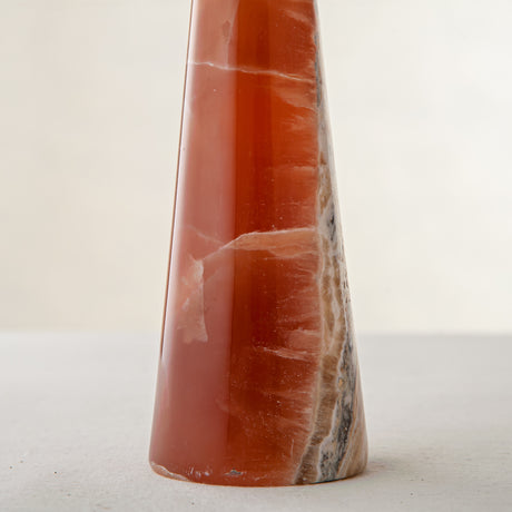 handcrafted orange onyx candle holder with tall sculptural form and translucent veining for modern decor
