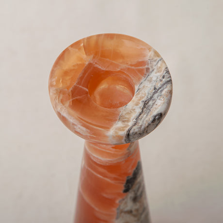 handcrafted orange onyx candle holder with tall sculptural form and translucent veining for modern decor
