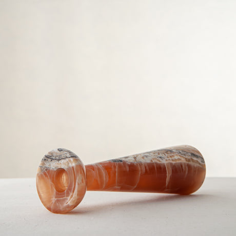 handcrafted orange onyx candle holder with tall sculptural form and translucent veining for modern decor
