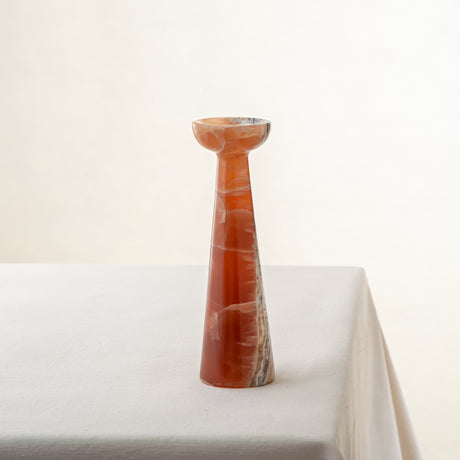 handcrafted orange onyx candle holder with tall sculptural form and translucent veining for modern decor
