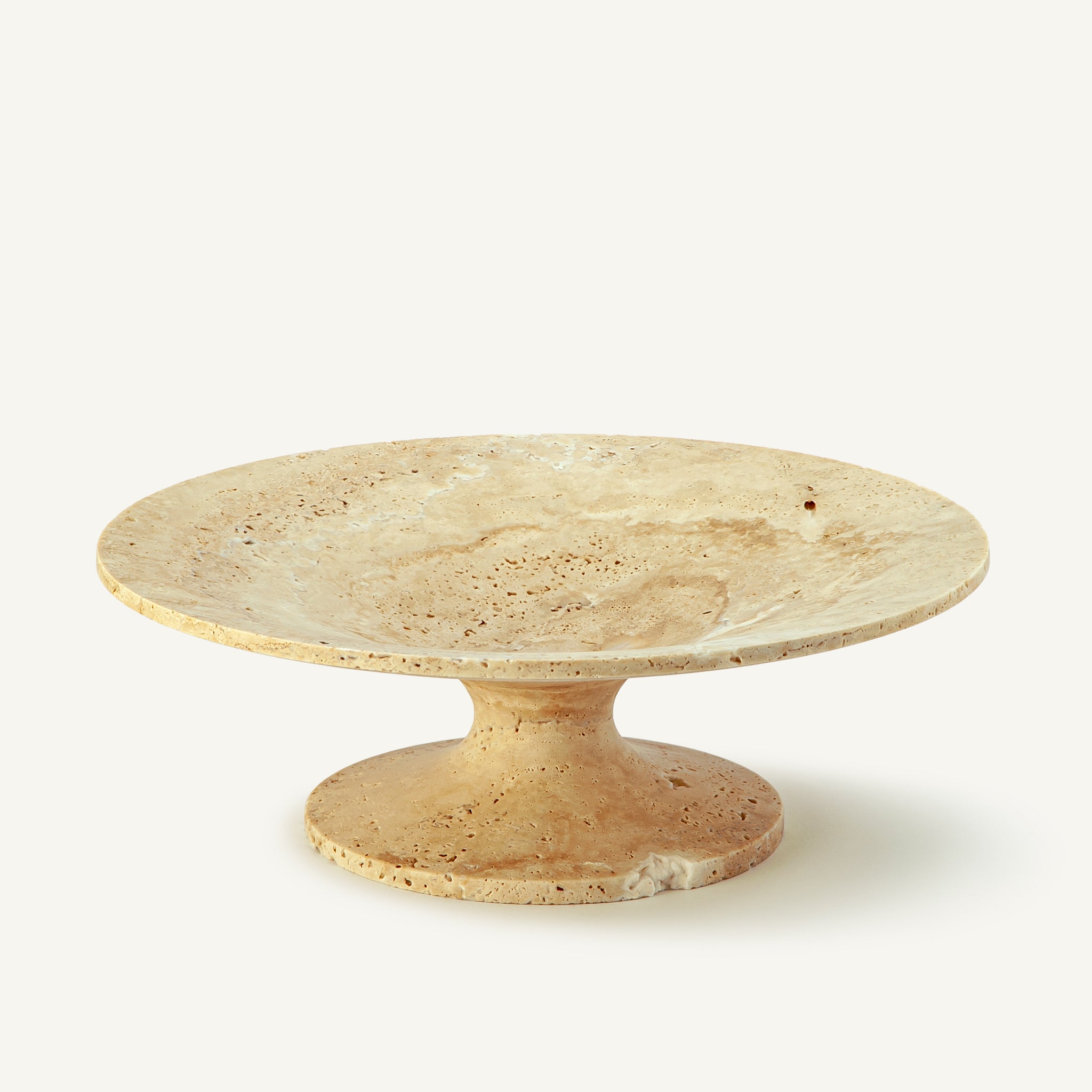 Handcrafted travertine cake stand with warm beige tones and natural porous texture for elegant table styling
