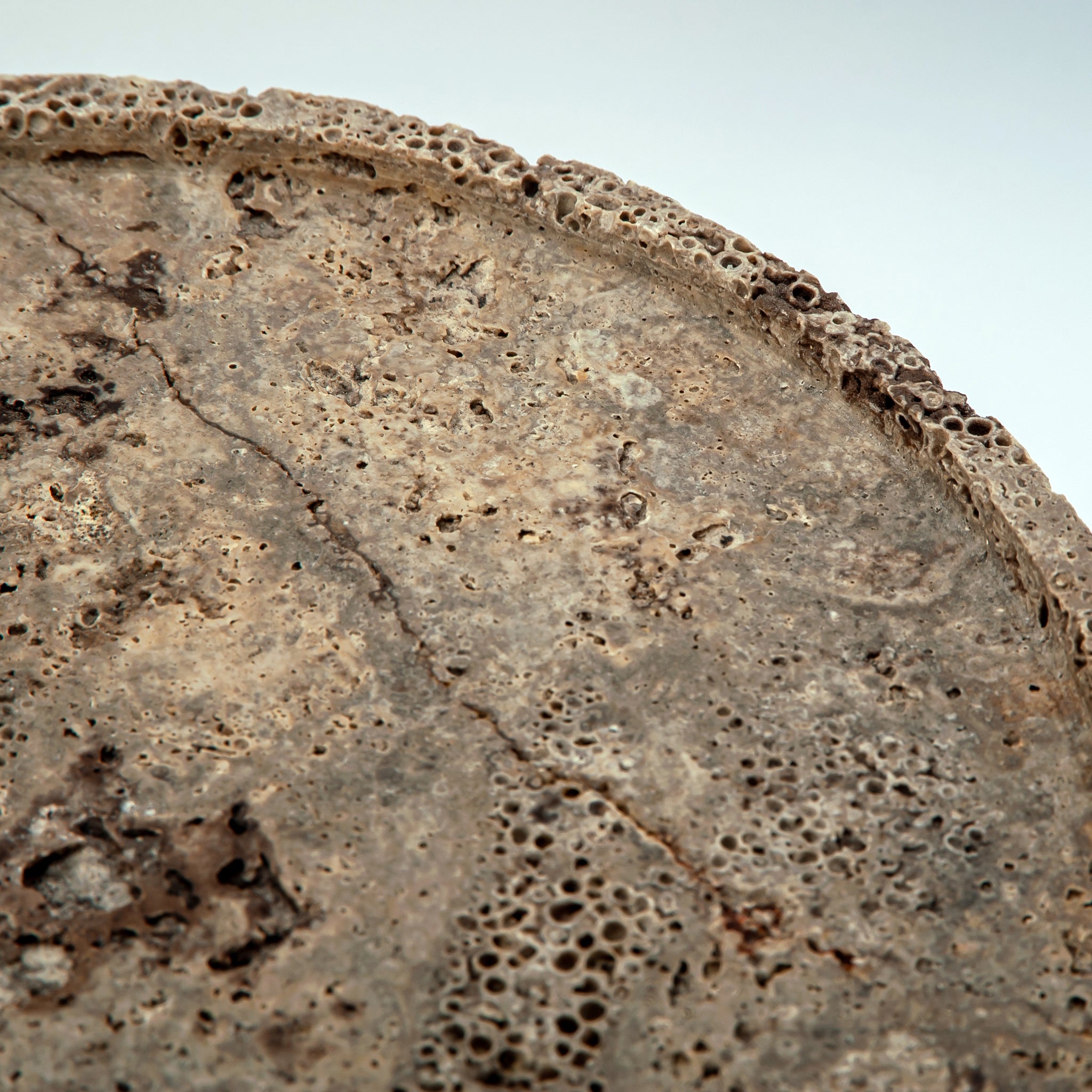 handcrafted travertine cake stand with porous texture and pedestal base for centerpiece display
