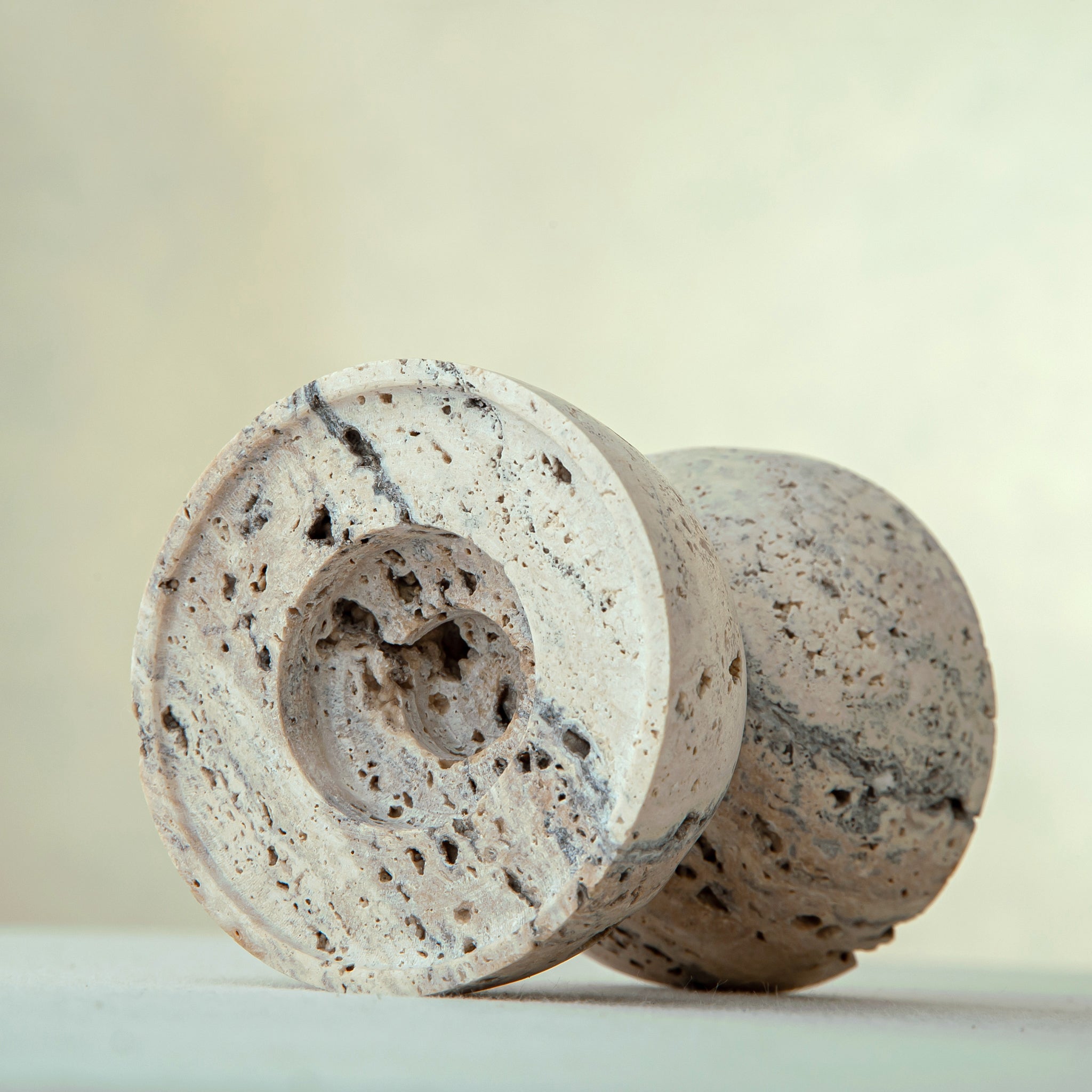 handcrafted travertine candle holder with porous texture and hourglass shape for modern decor
