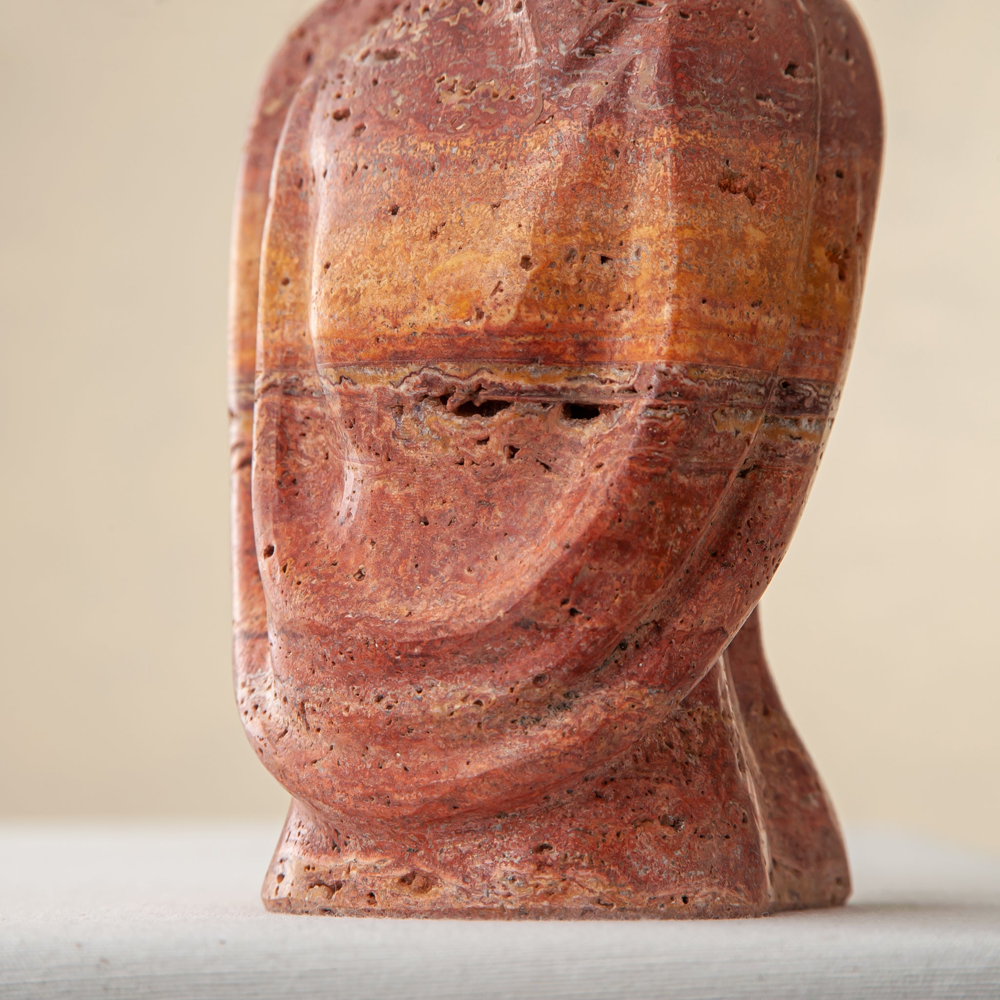 handcrafted travertine sculpture organic texture red stone intimate form interior styling
