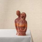 handcrafted travertine sculpture organic texture red stone intimate form interior styling
